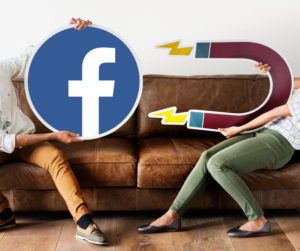 Entenda qual é a importância do tráfego pago para os negócios - Duas pessoas sentadas em um sofá marrom, segurando ícones grandes de um ímã e do Facebook